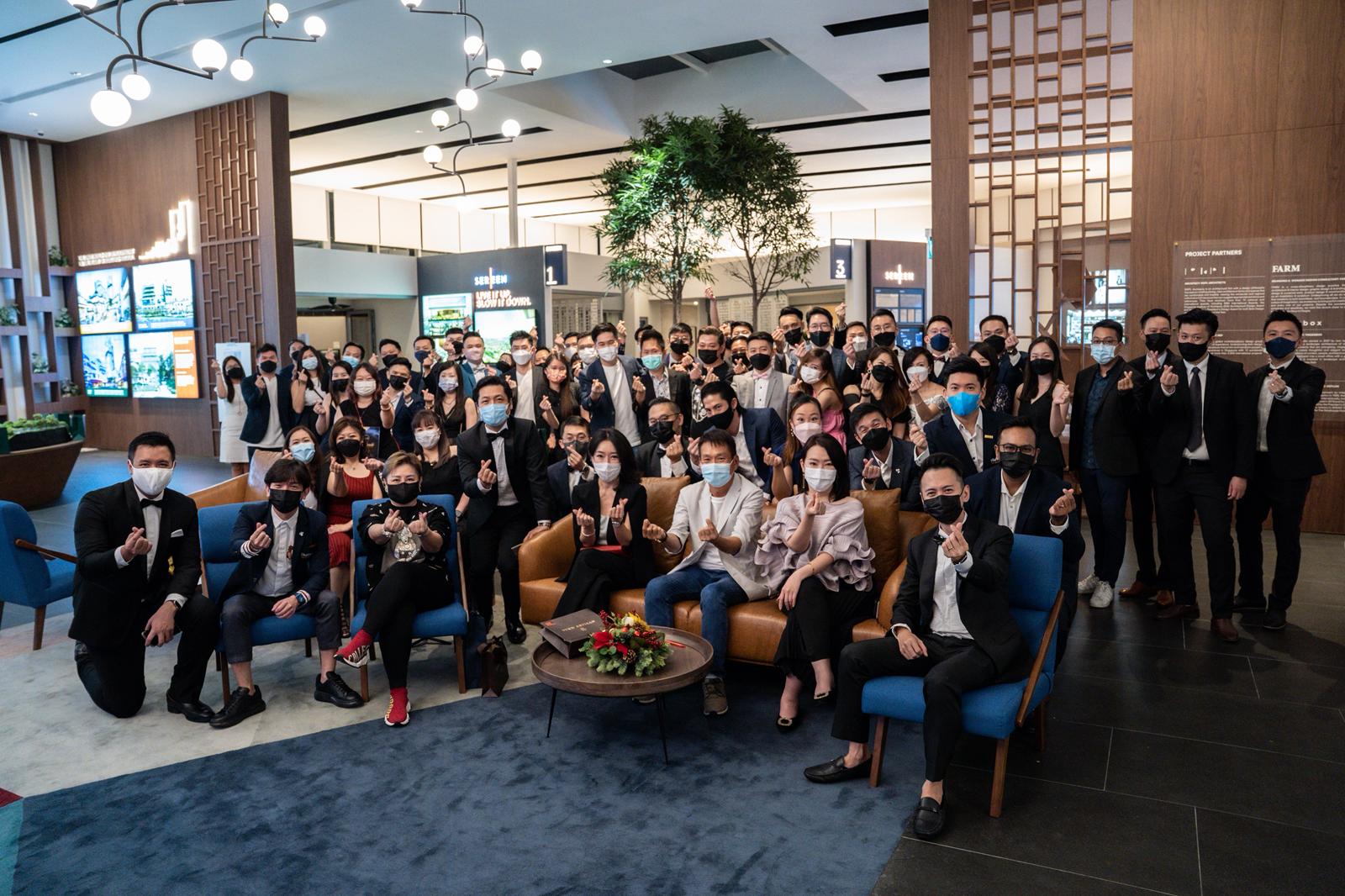 The Fendy Lee Group team gathered in a modern project showroom, masked and giving thumbs up