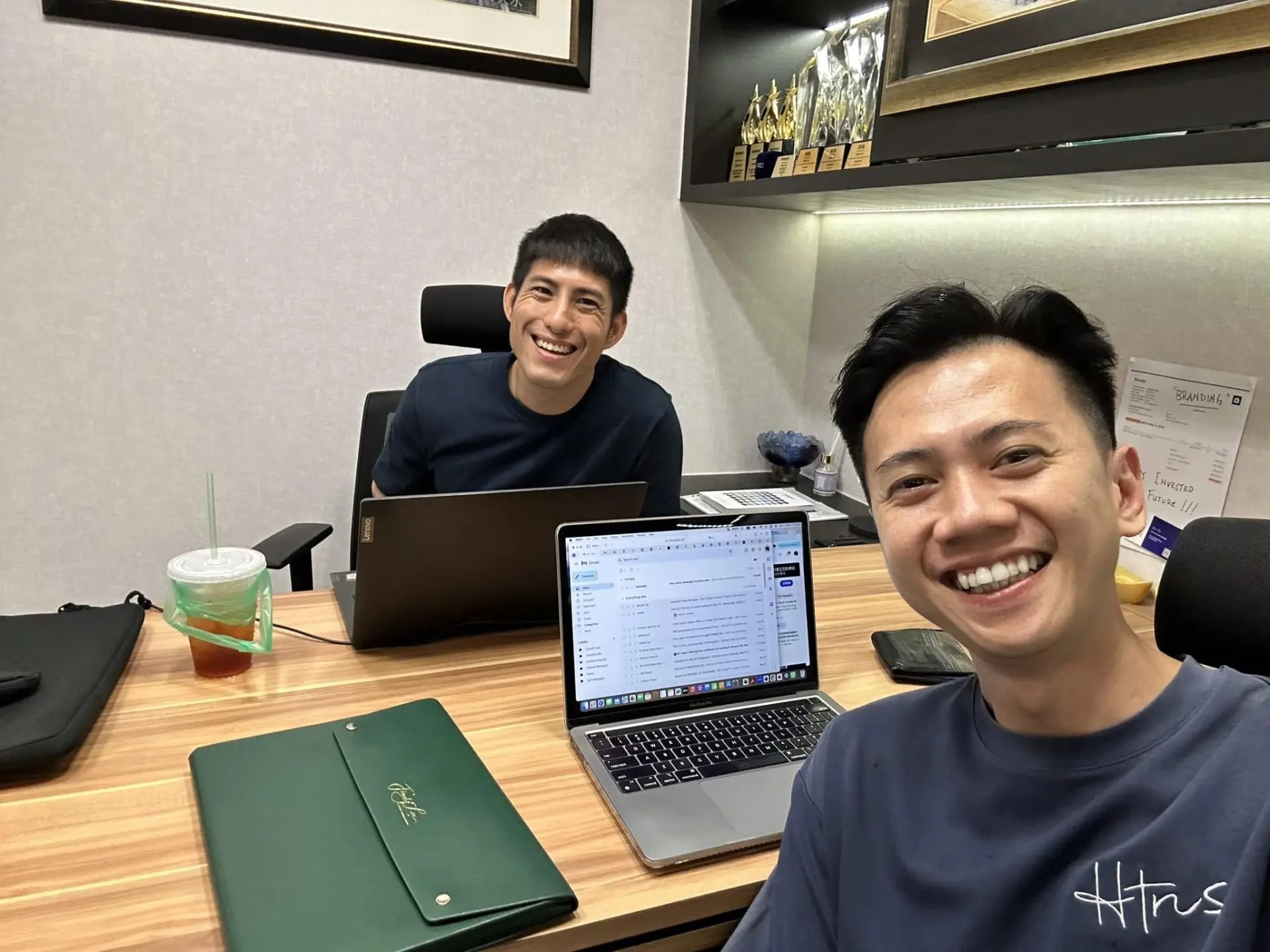 Two team members working at their laptops in the office
