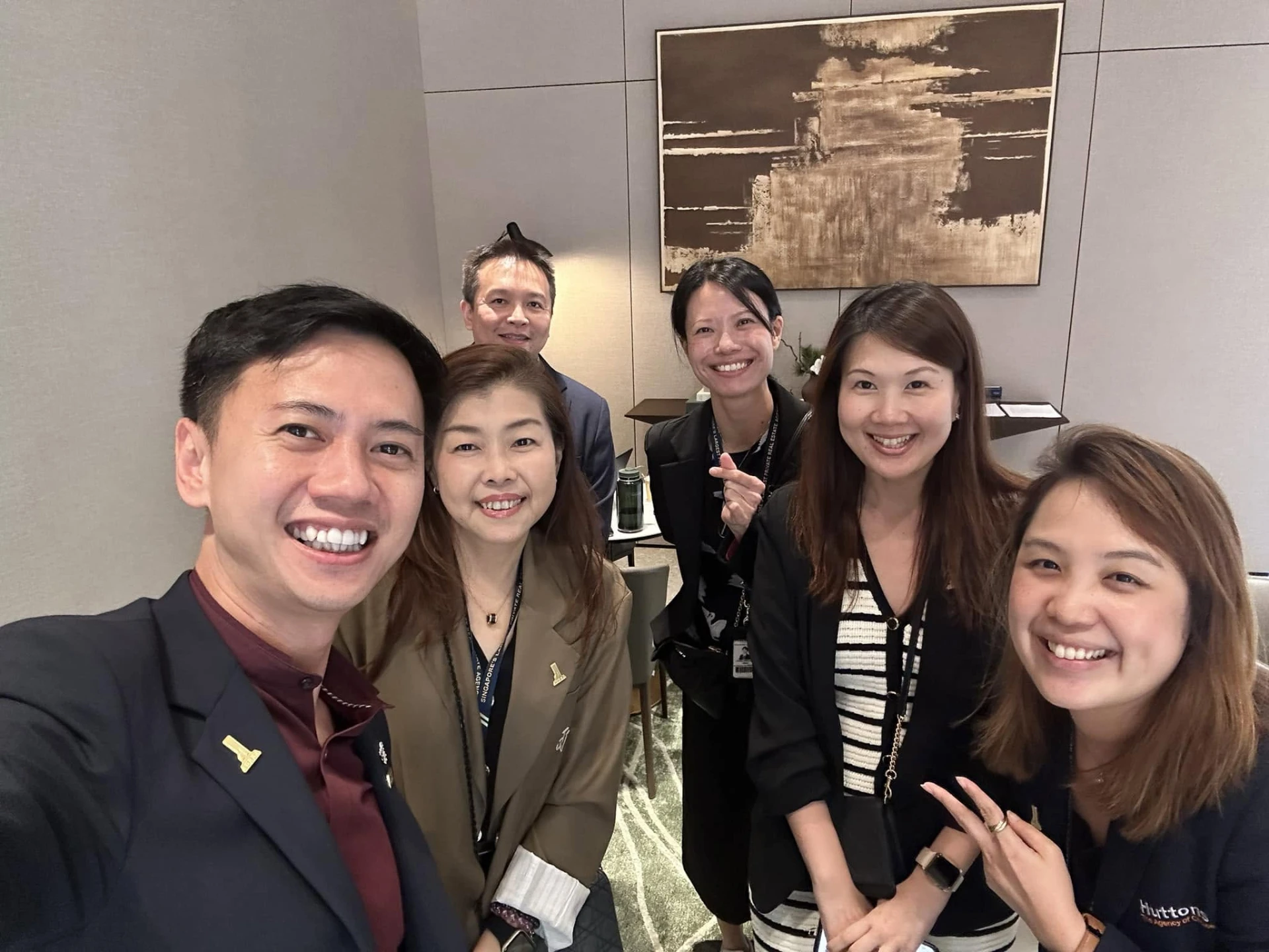 Fendy taking a selfie with colleagues in a modern showroom lounge