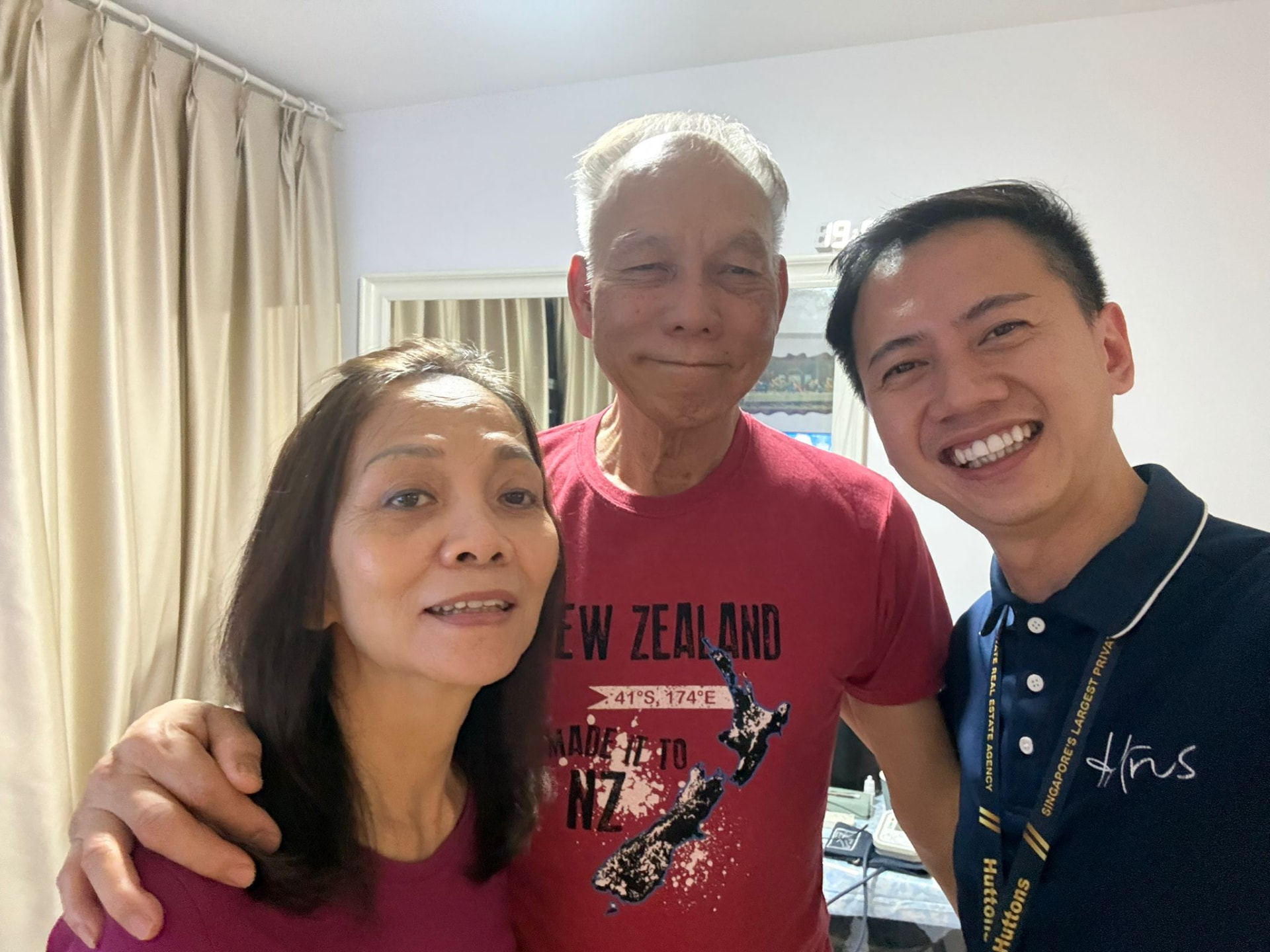 Fendy taking a selfie with a couple in their home